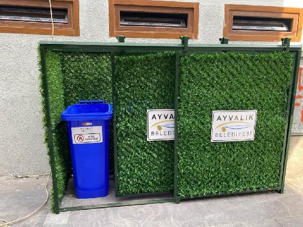 Ayvalık'ta çöp konteynerlerinin etrafı suni çimle kaplanıyor